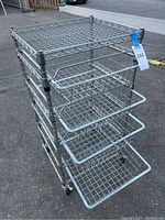 Full view of the rolling wire rack showing four pull-out wire mesh basket drawers and caster wheels.