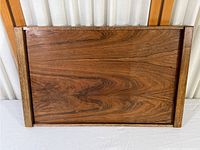Top-down view of vintage wood serving tray showing wood grain and rectangular shape with raised wooden edges