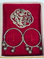 Overall view of pendant and earrings set in glass-topped gift box with red velvet interior