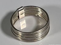 Close-up image of the sterling silver hose stacked ring showing the stacked thin bands and silver clasp holding them.