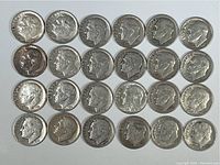 Top-down view of 24 Roosevelt dimes arranged in 4 rows, showing obverse details including dates and Roosevelt profile, confirming pre-1965 silver content.