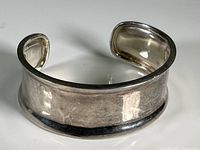 Top view of the silver cuff bracelet showing polished surface with slight wear.