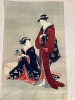 Close-up photo of the vintage Japanese print showing two women in traditional kimonos against a green background.