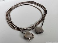 Full view of vintage sterling silver chain with loop clasp laid on white surface showing chain length and clasp.