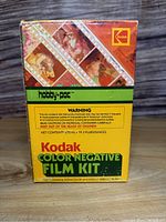 Front view of Kodak Color Negative Film Kit box showing brand, product name, warning about chemicals, and net contents of 572 ml.