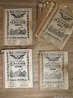 Top view of eight antique Hagerstown Town and County Almanacks with visible dates 1933, 1936, 1937; all show paper wear and yellowing
