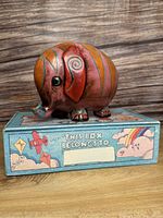 Wooden elephant piggy bank sitting on top of the blue pencil case box showing front and side details