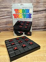 Front view of boxed vintage Think Tac Toe solitaire puzzle game with game board and pieces arranged on a wooden surface.