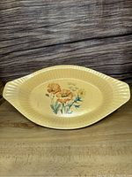 Full view of the large oval casserole dish showing its shape, ridged edges and floral decoration.