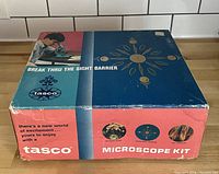 Top view of vintage TASCO microscope kit box with colorful graphics and branding