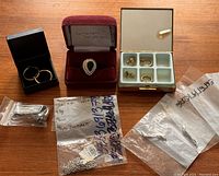 Overview of all the jewelry pieces including rings, earrings, and chains mostly in boxes and plastic bags