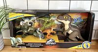 Front view of boxed Fisher-Price Imaginext Jurassic World Raptor Raid toy set showing main dinosaur figures and packaging