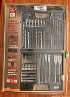 Front view of Ultra Steel 81-piece power drill bit set in plastic case showing multiple drill bits, screwdriver bits, and spade bits with packaging showing branding and product details.