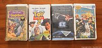 Front view of all four vintage VHS tapes in original sealed condition: The Jungle Book, Toy Story 2, E.T., and El Dorado.