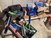 Motomaster Air Machine 120V air compressor in original box with gauge and hoses shown alongside automotive cleaning supplies, vacuum cleaner, snow brushes, and automotive tools.