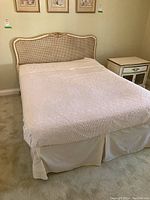 Full view of headboard, metal frame, and bedspread installed on bed