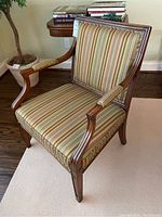 Full angled view showing wood frame and striped fabric upholstery of armchair.