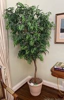 Full view of the faux tree in the plastic pot showing its height and foliage size.