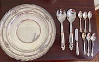 Full view of tray, salad servers and teaspoons laid out on surface