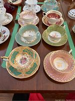 Eight teacup & saucer sets arranged on table