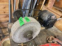 Close-up image of the bench grinder's grinding wheel showing surface texture and bolt attachment.