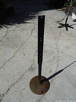 Full view of the tall sign stand with cast iron base on outdoor pavement