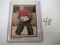 Front image of 1990 OPC Premier Patrick Roy hockey card showing Roy in goalie stance with Canadiens uniform and gear.