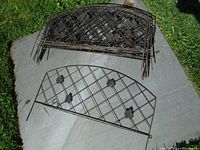 10 metal garden fence panels stacked with visible lattice pattern and floral decorations.