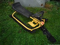 Photo of GT Snow Racer sled showing side profile, yellow frame, black seat and skis