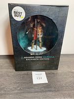 Front view of Eivor vinyl figure inside black packaging with circular window and Best Buy exclusive sticker