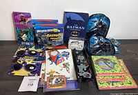 Full lot overview showing assorted Batman merchandise including keychain, sunglasses, books, watch, lunchbags, and folders.