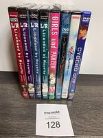 Front view of eight anime DVDs lined up, including four L/R Mission File volumes, Girls und Panzer, Tweeny Witches, Dragon Ball Z Movie, and Cyborg 009. Mostly sealed with visible spine titles.