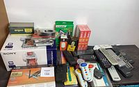 Wide view of entire lot showing printer box, adapters, remotes, media storage and accessories