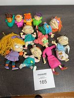 Photo showing a collection of Rugrats character figures including dolls and finger puppets arranged on a flat surface.