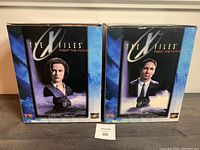 Front view of Mulder and Scully bust statue boxes