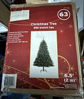 Box front showing product details including 6.5 feet height, 996 branch tips, metal stand included, and Holiday Collection branding