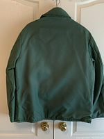 Back view of the green FLOTEX flotation jacket with collar and simple design.