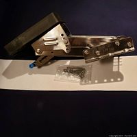 Side view showing the stainless steel bracket with folding composite plate and included mounting hardware in clear plastic bag.