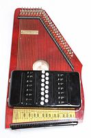 Full top-down view of autoharp showing body, strings, chord bar assembly and soundhole.