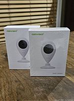 Two ORVIBO smart camera boxes, one sealed and one opened, showing product packaging with branding and camera image.