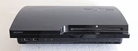 Front view of PS3 console showing disc slot and USB ports.