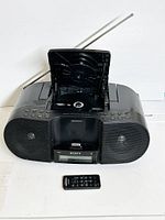 Front view of Sony boombox with CD player lid open, showing docking station and remote control placed in front.