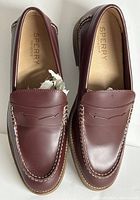 Top view showing burgundy leather loafers with white stitching and Sperry branding on insole.