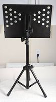 Photo of the light-duty adjustable metal music stand with perforated sheet metal desk and tripod base.