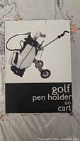 Box showing the golf cart pen holder image and labeled 'golf pen holder on cart'.