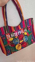 Front view of colorful handmade Guatemalan bag with floral embroidery and the word 'GUATEMALA'