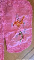 Photo showing the first silk pillowcase, pink with golden-orange dragon embroidery and gathered pink border.
