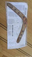Photo of a new Duncan Maclennan 455m boomerang still sealed in plastic packaging with instructional leaflet.