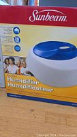 Photo showing front of boxed Sunbeam cool mist humidifier with brand and model information visible.