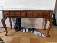 Front view of the solid wood console table with 2 drawers and curved legs, showing the detailed woodwork and knobs.